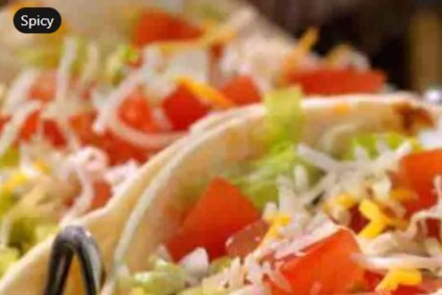 Close Up Of Fresh Tacos With Shredded Cheese, Diced Tomatoes, And Lettuce, Marked With A 