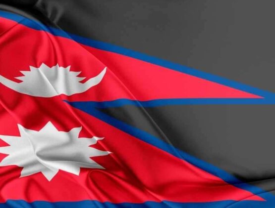 The National Flag Of Nepal, Featured On Lalmon.com, Maintains Its Unique Non Rectangular Shape With Two Triangular Sections In Red With A Blue Border, And White Stylized Moon And Sun Emblems